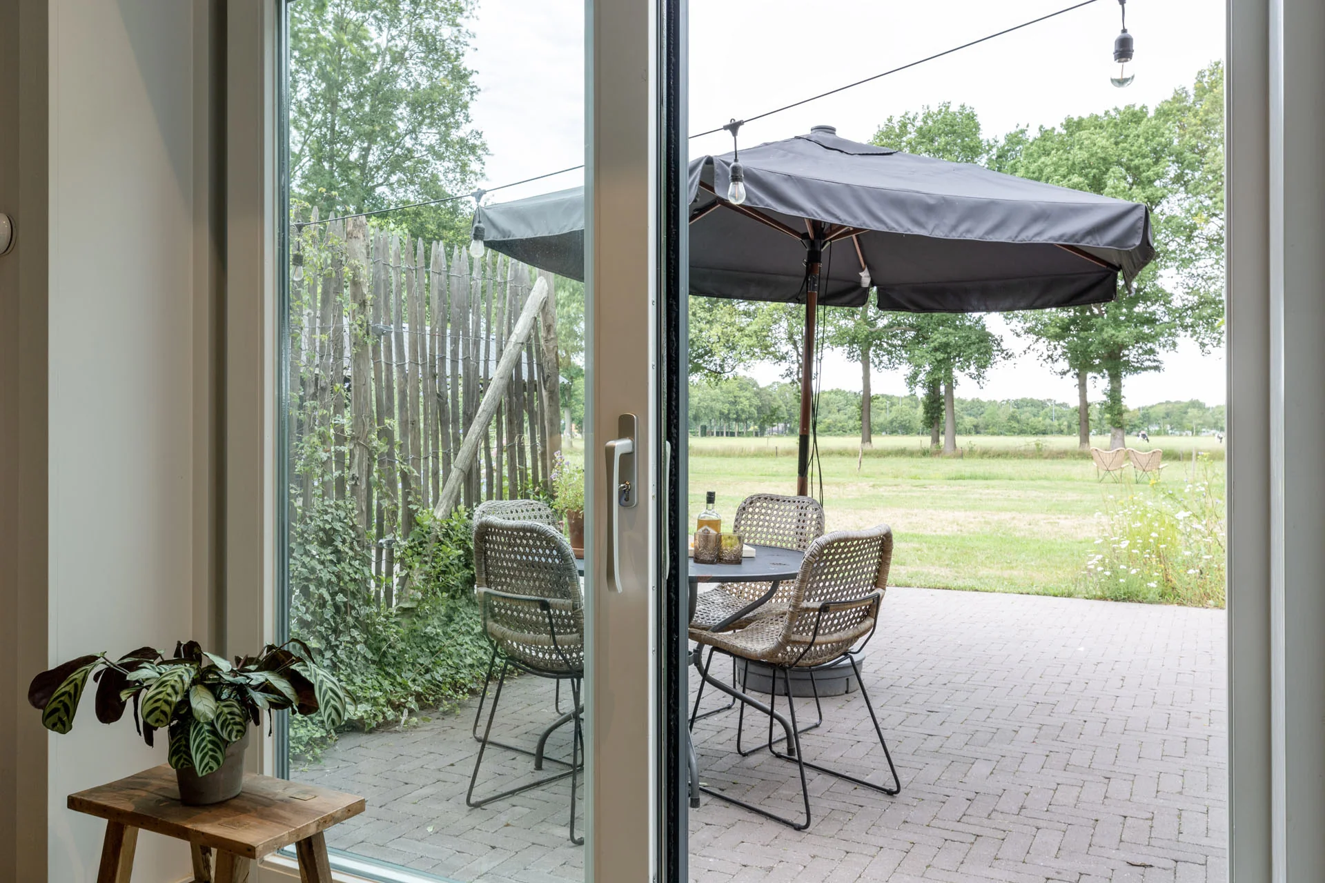 Uitzicht vanuit het appartement op het terras en de groene landerijen