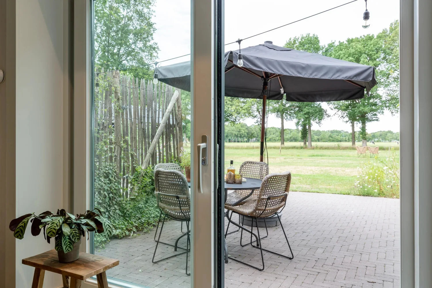 Vanuit het appartement uitzicht op het eigen terras en de groene wei